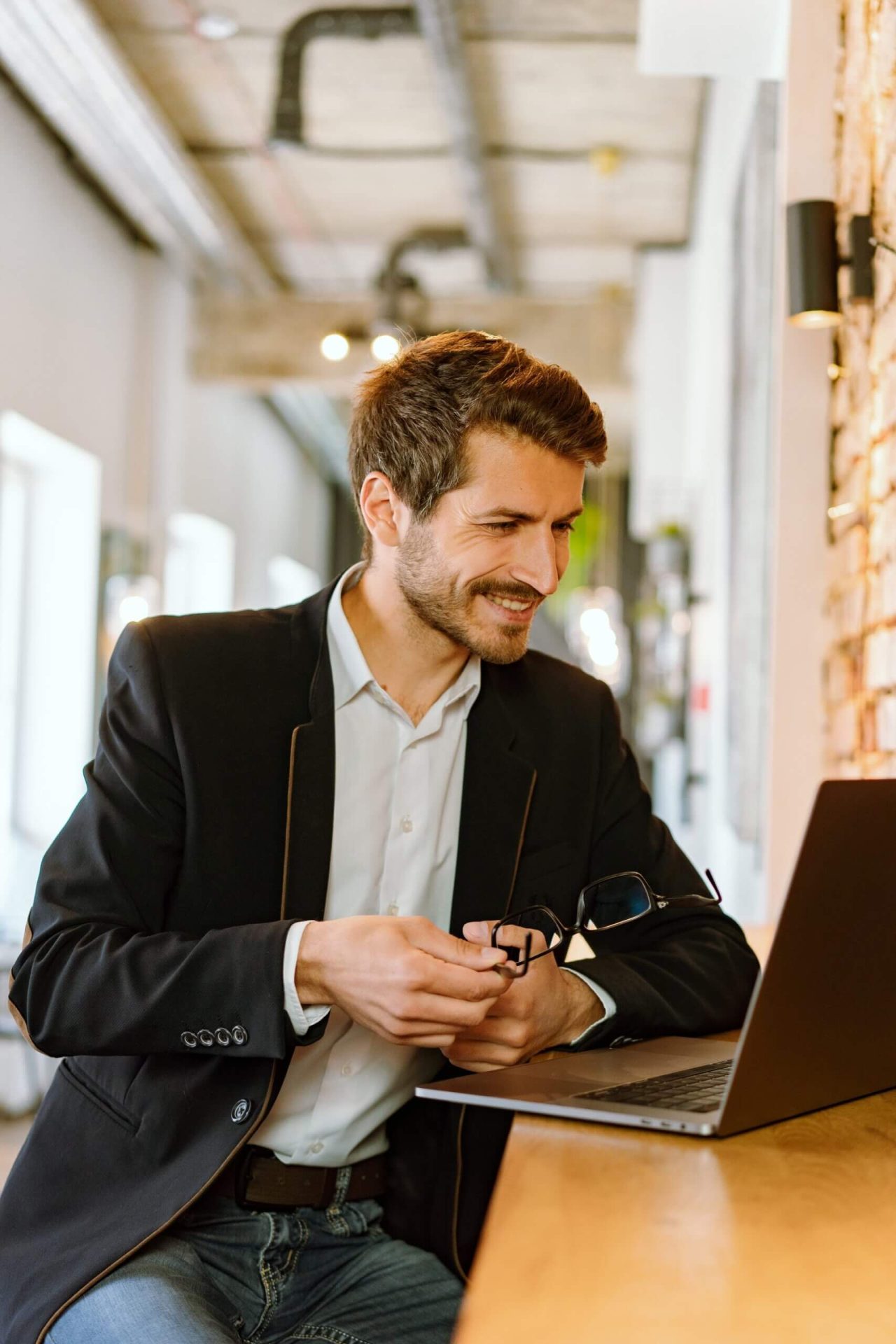 A smartly dressed man looking at a laptop to represent e-learning